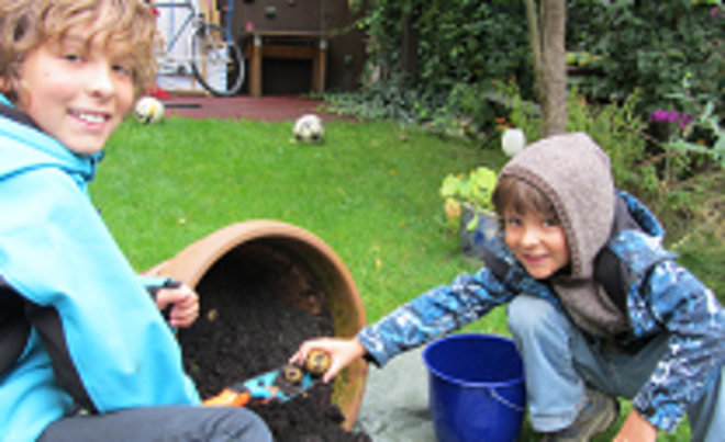 Zwei Kinder pflanzen in einem Top mit Erde Kartoffeln. Weiterverlinkung auf swa Kids Spiel und Spaß Seite